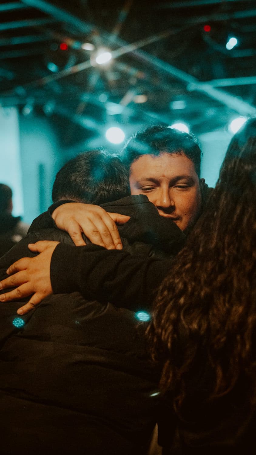 Dos personas abrazándose en una reunión de la iglesia